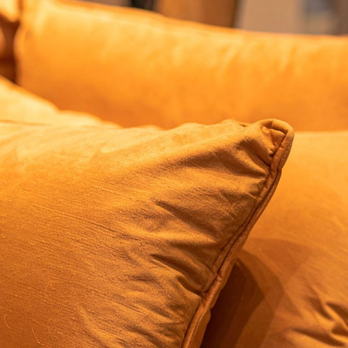 Soft orange throw pillows with smooth fabric in a cozy home setting