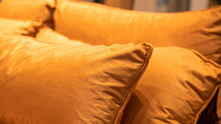 Soft orange throw pillows with smooth fabric in a cozy home setting