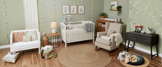 Cozy nursery room with white crib, rocking chair, dresser, and nature-themed decor