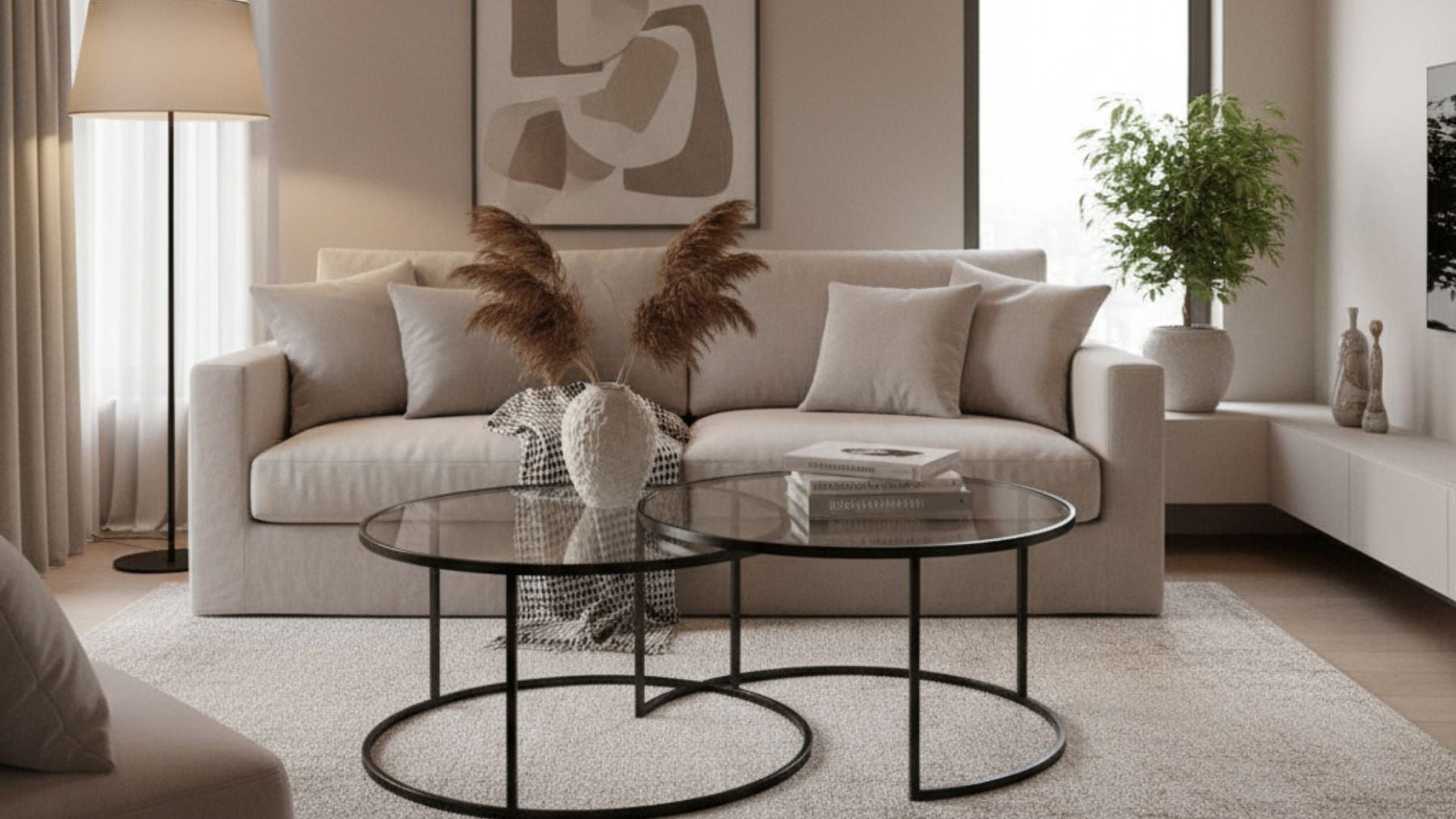 Modern living room with beige sofa, decorative pillows, glass coffee tables, and indoor plants