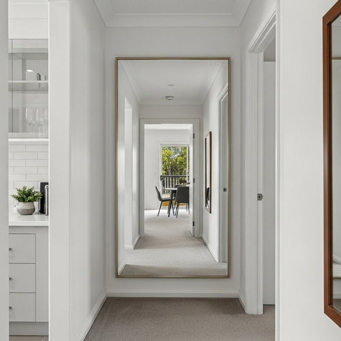 Modern hallway with large wall mirrors, neutral decor, and a glimpse of a dining area