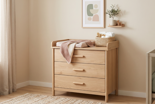 Changing table with three drawers in a calm, elegant nursery.