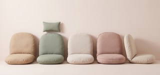 Range of egg chair cushions in soft tones on a pastel backdrop.