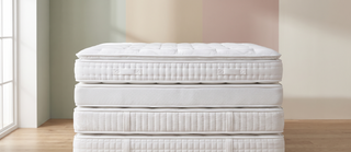 Range of king size mattresses in different styles on a pastel backdrop.