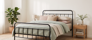 Elegant metal bed frame dressed in pastel linen in a calm, elegant bedroom.