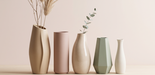 Range of modern vases in sculptural shapes on a pastel backdrop.