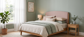 Queen size bed dressed in pastel linen in a calm, elegant bedroom.