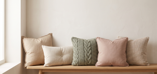 Range of sofa cushions in soft textures on a pastel backdrop.