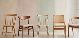 Range of wooden dining chairs in different styles on a pastel backdrop.