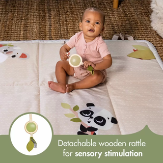 Baby sitting on a panda-themed play mat holding a detachable wooden sensory rattle.