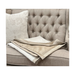 Full view of the throw laid out to showcase its design and colours in a natural light setting