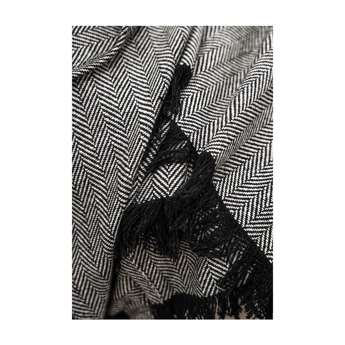 Close-up of the plush fabric and tassel edge of the sophisticated throw