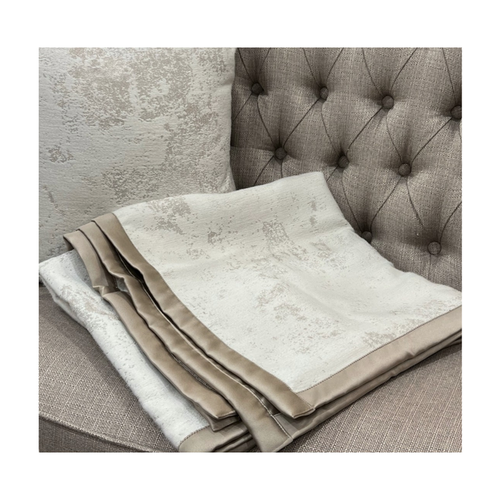 Folded throw showcasing the intricate gold pipping details