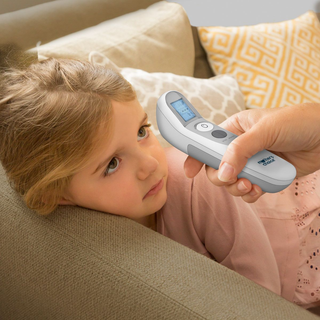 Digital forehead thermometer measuring temperature of a child at home