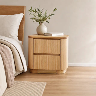 Adsila 2-Drawer Bedside Table styled in a calm, modern Australian bedroom beside a warmly dressed bed.