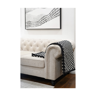 Stylish black and white throw spread on a Sofa, enhancing the room's decor