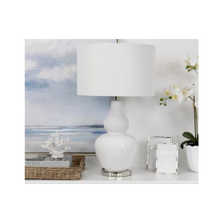 Coastal White Classic Table Lamp With White Shade next to picture frames