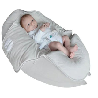 Infant reclining in soft beige baby bean bag chair with safety harness
