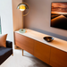 MVP Suite gold lamp on console beside TV in modern living room with warm lighting.