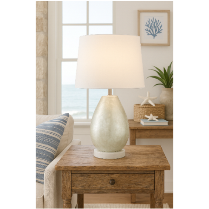 Pearl Capiz Lamp on wooden side table in coastal living room overlooking ocean.