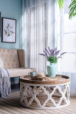 Cozy living room with beige tufted sofa, Rustic Moroccan Inspired Wooden Coffee Table and lavender vase decor.