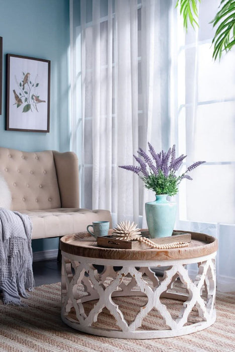 Cozy living room with beige tufted sofa, Rustic Moroccan Inspired Wooden Coffee Table and lavender vase decor.