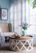 Cozy living room with beige tufted sofa, Rustic Moroccan Inspired Wooden Coffee Table and lavender vase decor.