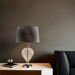 Sheridan Glass Lamp with Silver Shade on console table beside sofa in modern living room.