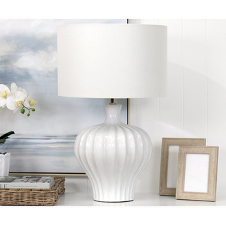 Tan’s White Ceramic Lamp styled on coastal console with orchid and ocean artwork, creating serene décor.