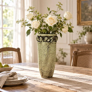Antique floral carved vase with white roses on rustic wooden dining table
