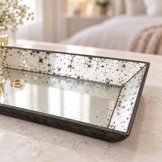 Antique rectangular glass tray speckled mirror corner close up on cream marble table