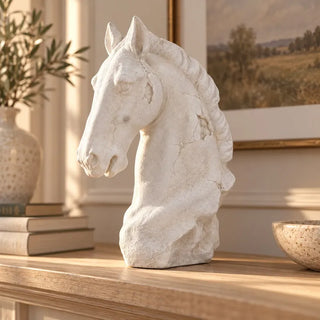 Antiqued white horse head bust on light oak mantel shelf beside olive branch vase