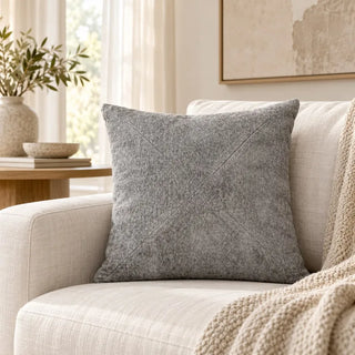Ash grey textured cushion in corner of cream linen sofa with knit throw