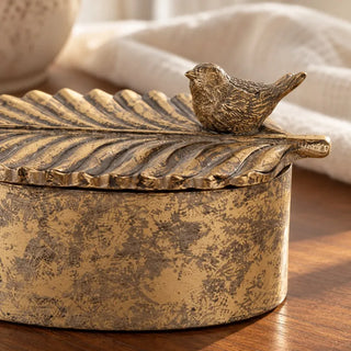 Avian elegance oval trinket box close up of sculpted bird on leaf shaped antique gold lid