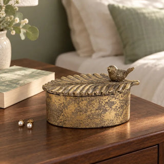 Avian elegance oval trinket box on walnut bedside table with pearl earrings and book