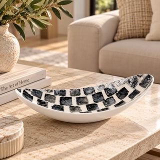 Black and white decorative tray on travertine coffee table with olive branches