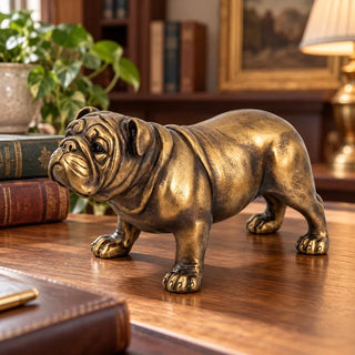 Bronze bulldog figurine on wooden desk beside leather bound books and potted plant
