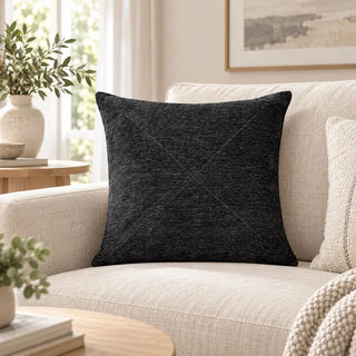 Charcoal textured cushion on cream sofa with chunky knit throw and oak coffee table