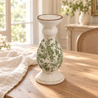 Cream floral ceramic candlestick on oak dining table with linen cloth and cane chair