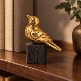 Gilded bird on stand figurine 15cm on walnut bookshelf beside linen books and bronze vase