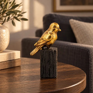 Gilded bird on stand figurine 18.5cm on round walnut side table by charcoal sofa