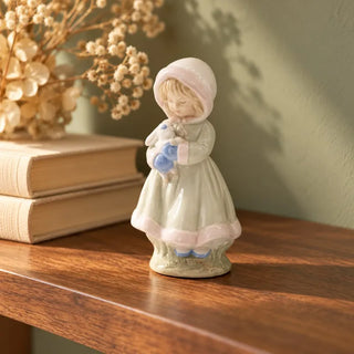 Girl holding rabbit figurine on walnut shelf beside stacked books and dried flowers