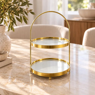 Gold high tea cake double tray on round marble dining table with greenery