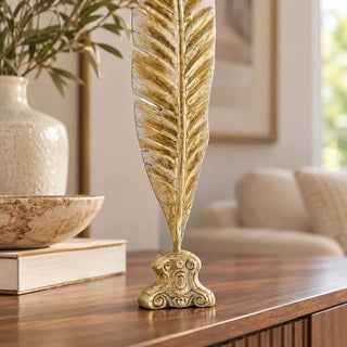 Gold leaf palm frond sculpture scrolled base close up on walnut sideboard