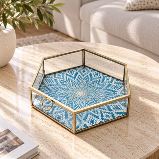 Hexagon blue box on round travertine coffee table with olive branch vase