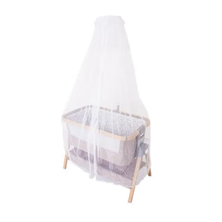 Baby bassinet with mesh canopy, wooden legs, and storage on white background.