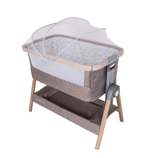 Modern baby bassinet with mosquito net, storage shelf, and wooden legs on white background