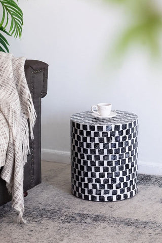 Black and white checkered side table with a coffee cup in a modern living room