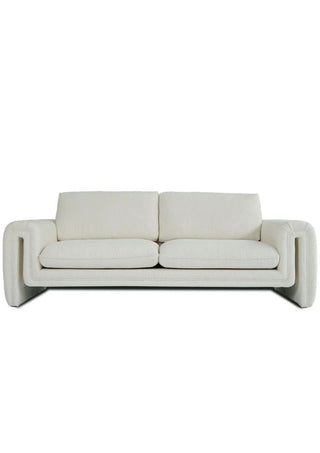 Modern cream three-seater sofa with plush cushions and curved armrests on white background