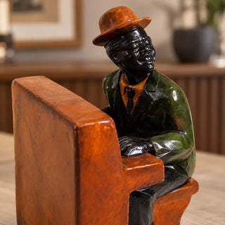 Jazz pianist statue close up of musician in brown bowler hat and green jacket